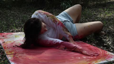 Lying on the canvas, the body merging with the painting
