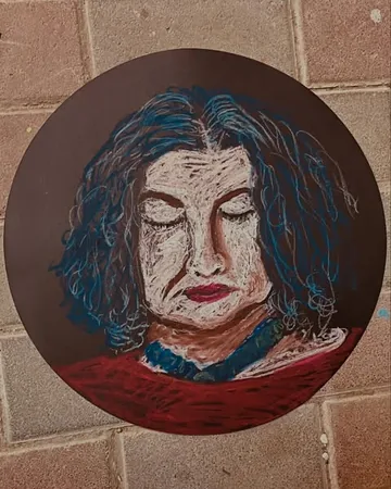 A round portrait painted on a brick wall