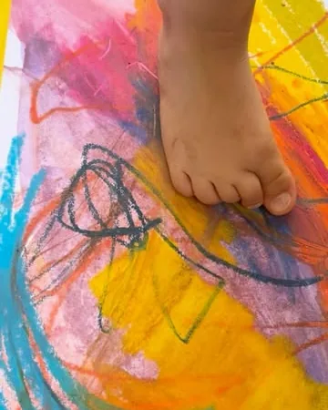 A foot on a colourful pastel painting